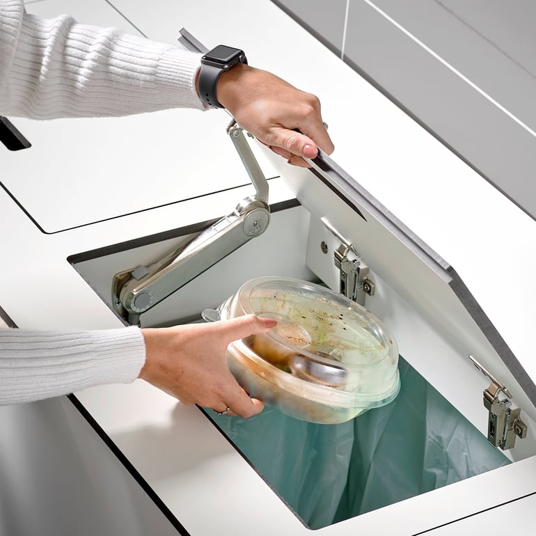 Woman throwing food waste into bin