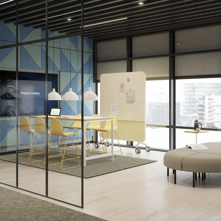 Meeting room with standing desk and tall chairs, and a modular stool seating area