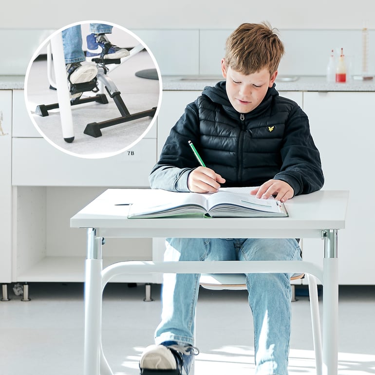 A child sitting and working at a classroom desk