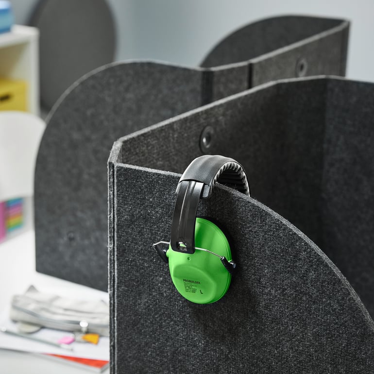 Ear protectors hanging from a privacy and sound-absorbing desk screen