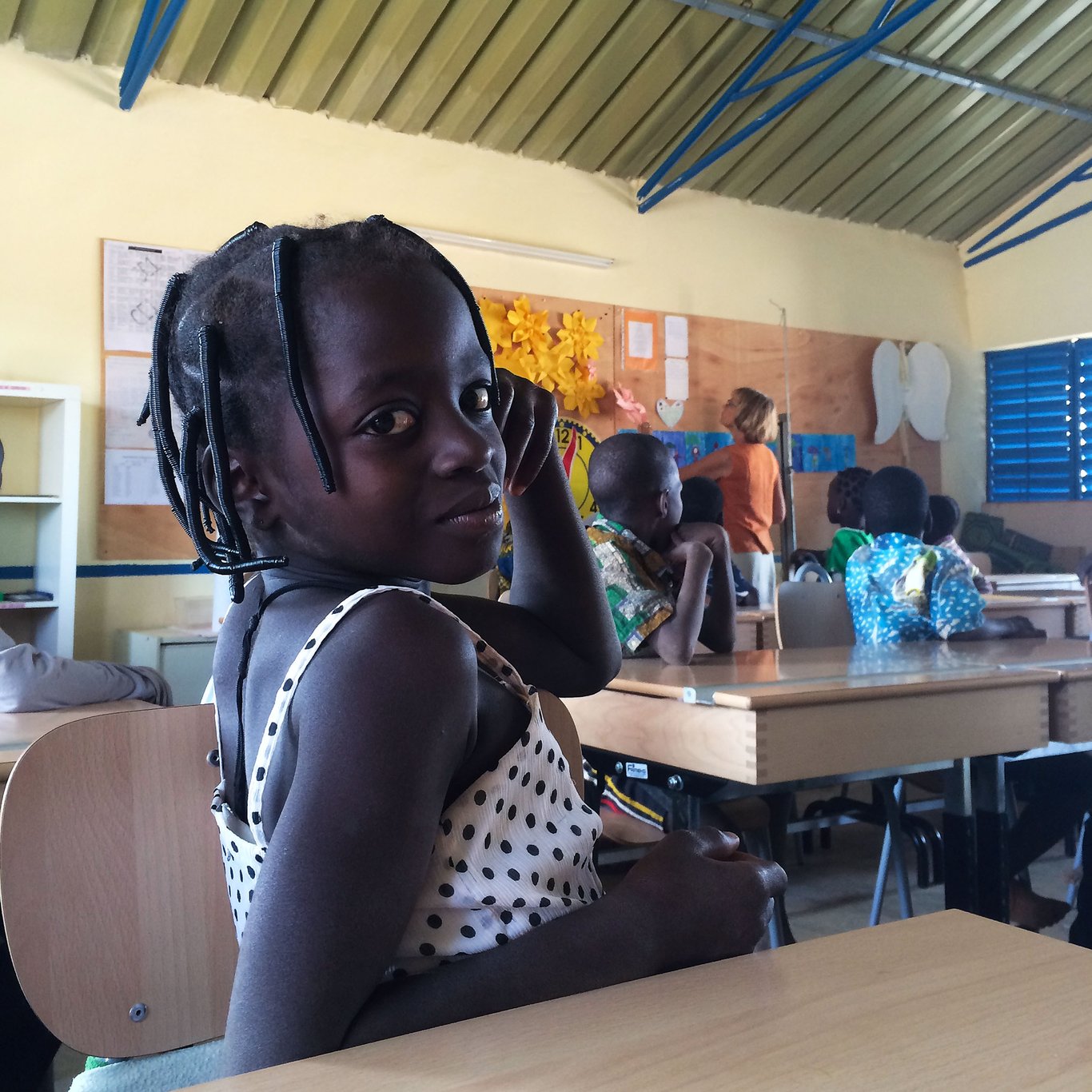 A girl in a classroom in Burkina Faso looks directly at the camera
