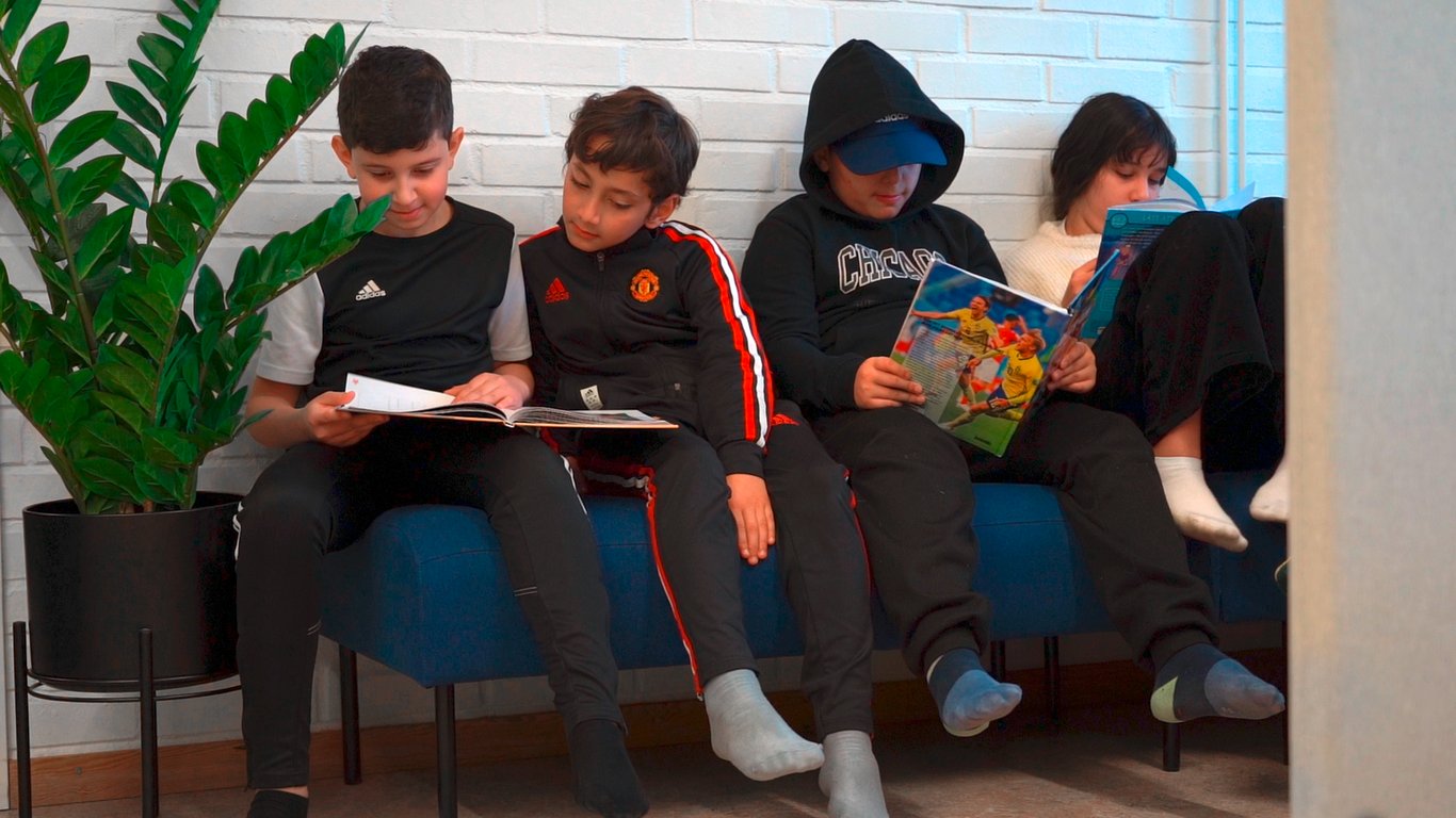 School children reading on a sofa