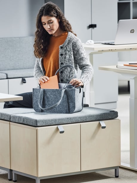 En kvinde pakker sin taske på et kontor