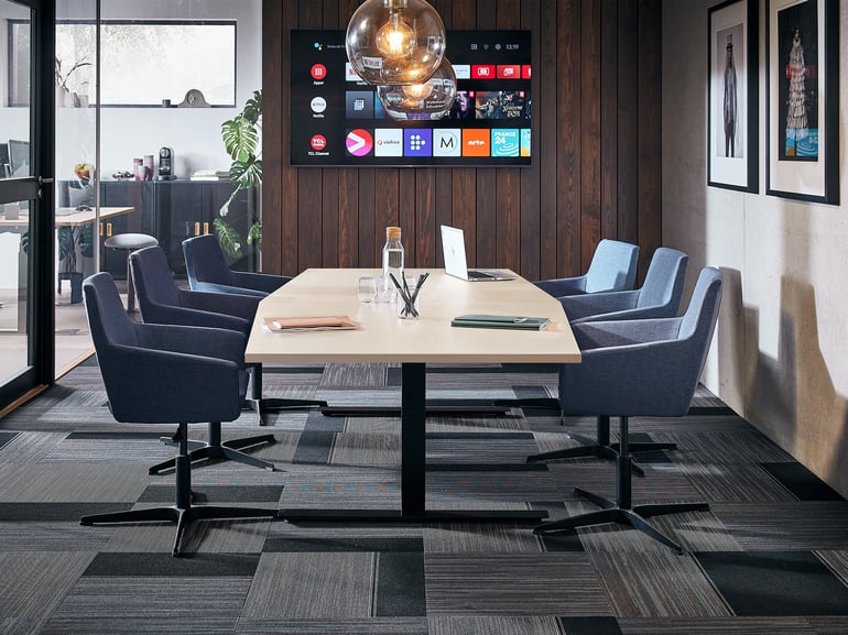 Ein Besprechungsraum mit Konferenztisch und blauen Stühlen