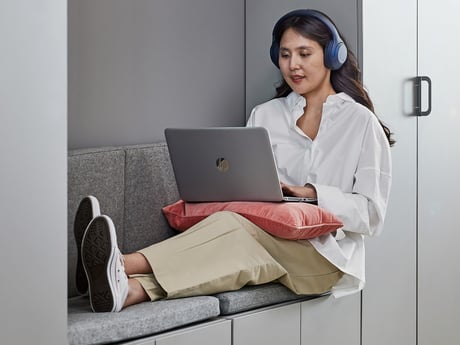 Eine Frau sitzt und arbeitet an ihrem Laptop