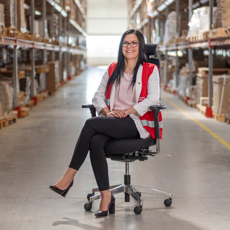 Female manager of AJ Furniture Factory sitting on a chair in the warehouse