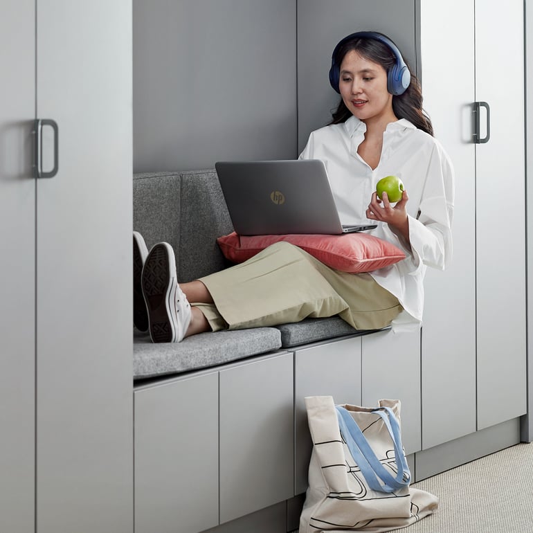 En person sidder med benene oppe og arbejder på en bærbar computer