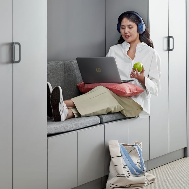 En person sidder med benene oppe og arbejder på en bærbar computer