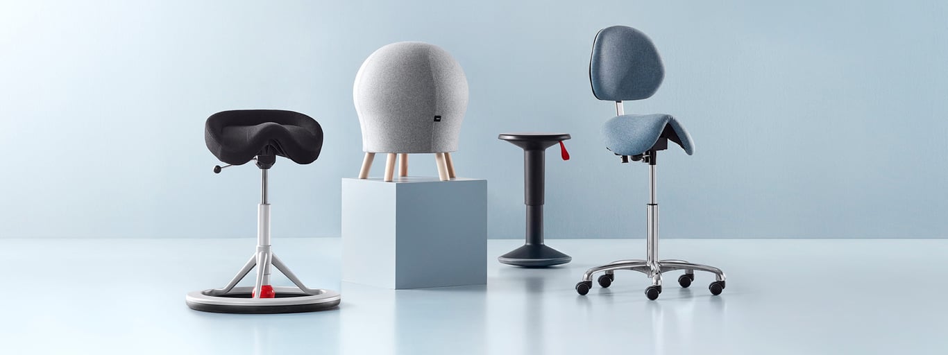 An assortment of active sitting chairs including two wobble stools, a saddle chair and a Pilates ball stool.