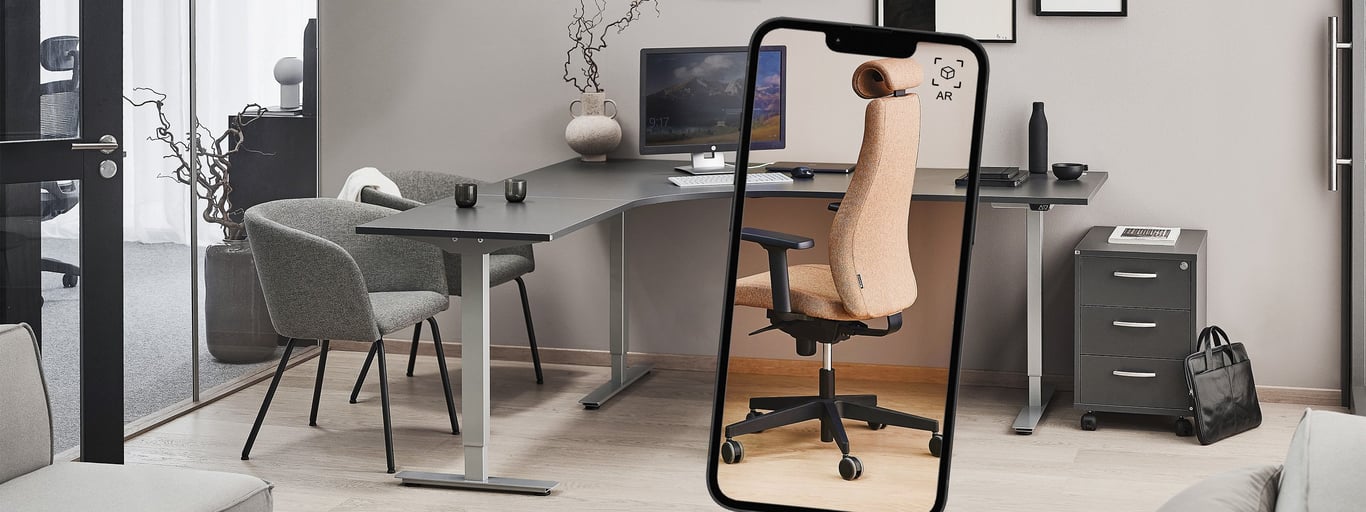 Et skrivebord i et kontormiljø, hvor en telefon viser en kontorstol gennem AR-funktionen