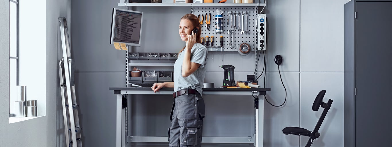 Woman standing at a sit-stand workbench