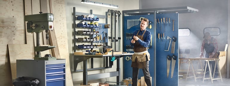 Man standing behind a workbench in a workshop