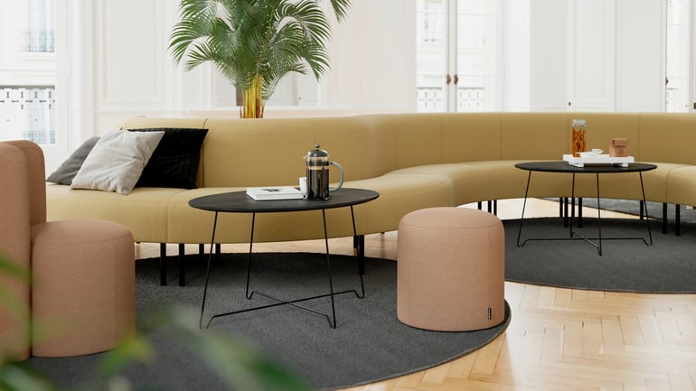 Long curved modular sofa with coffee tables and pouffes