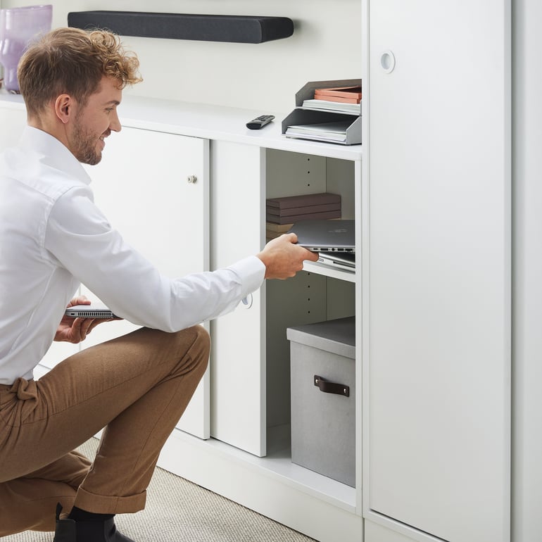 man looking in office storage cabinet