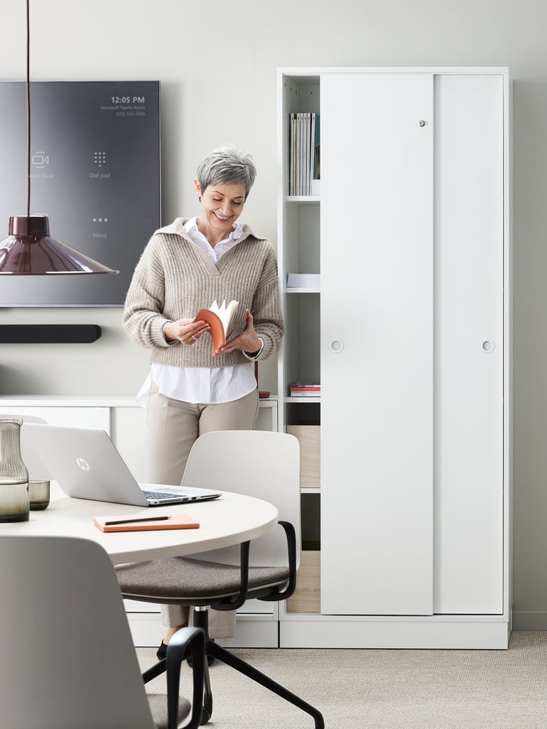 Woman in front of tall office storage cabinet