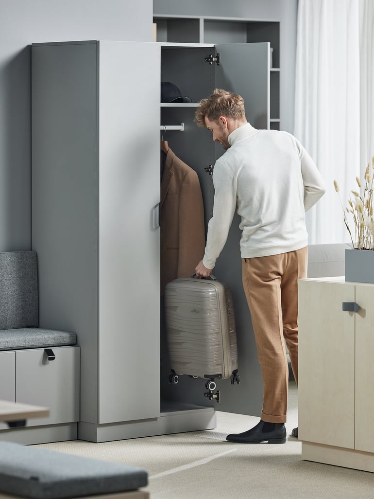 man looking in tall office storage cabinet
