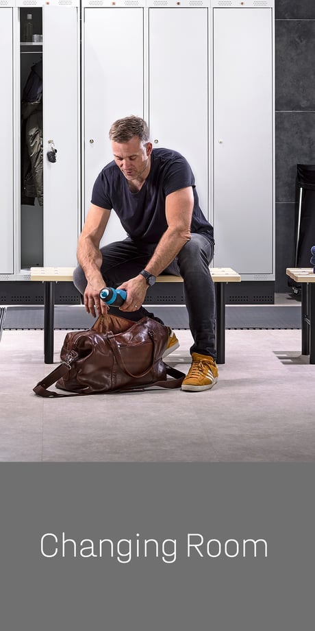 Changing room - man sitting on a bench in front of lockers