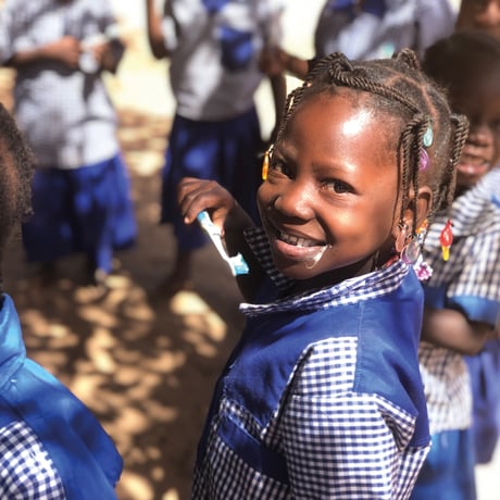 En pige fra en skole i Burkina Faso ser smilende på kameraet