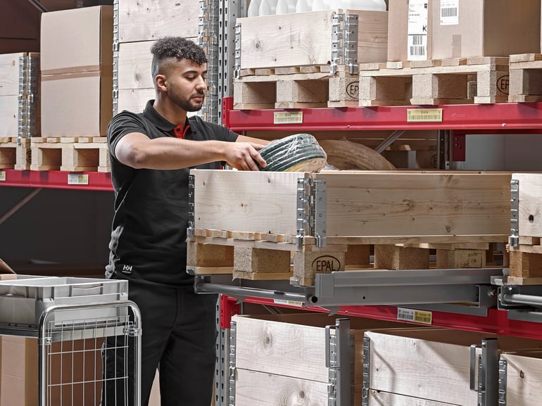 A person putting away stock on pallet racking