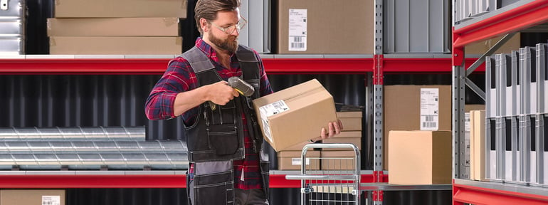 A person scanning a parcel in a warehouse