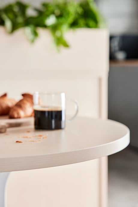 En kop kaffe står på et rundt bord