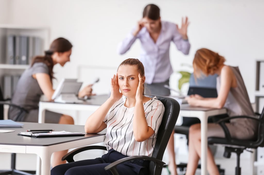 En kvinde er genereret over støj på kontoret