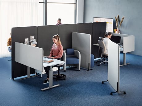 Et åbent kontor med lydabsorberende skillevægge i forskellige størrelser og farver